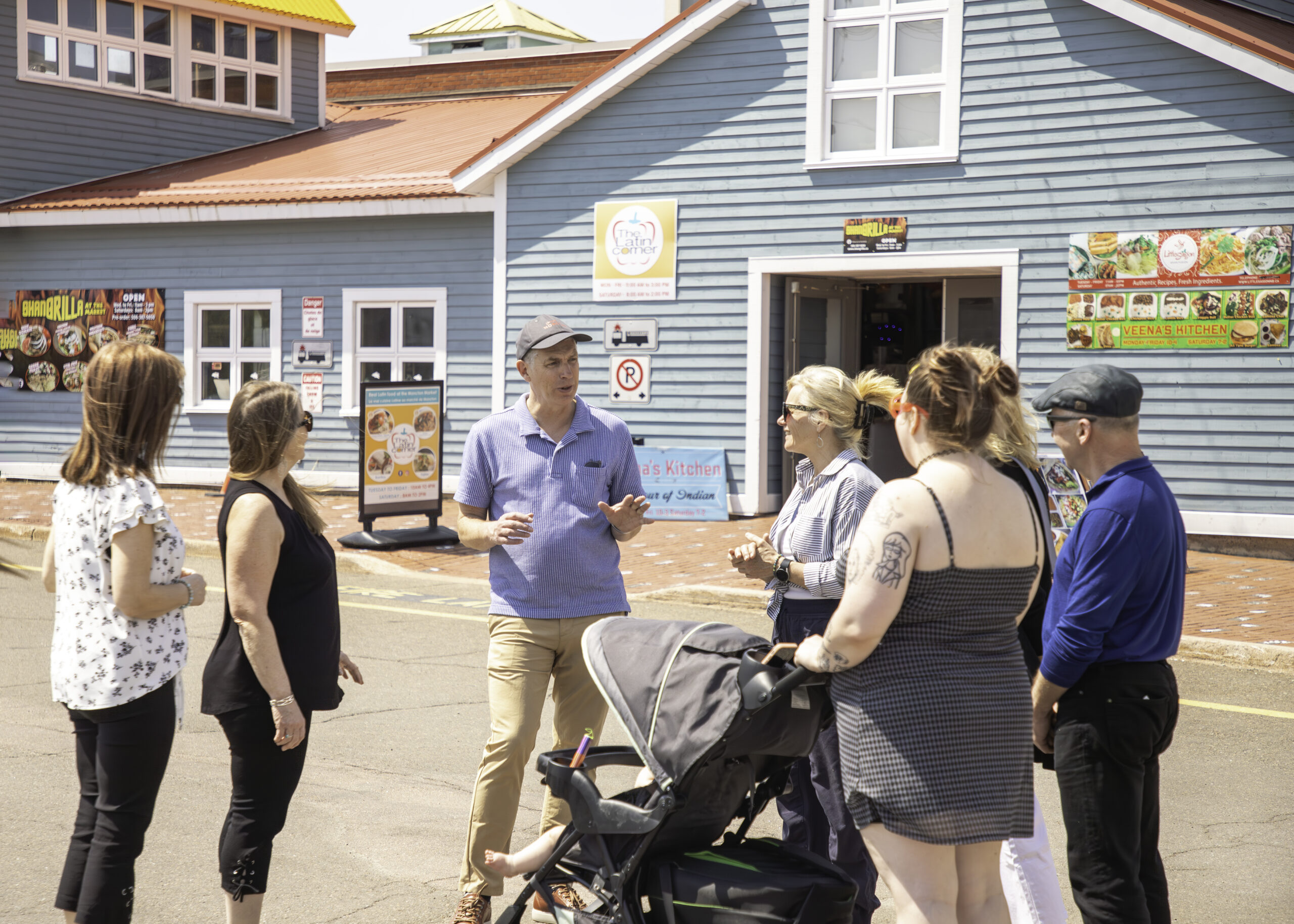 Tour guide talking to a small group of adults about the building behind him.